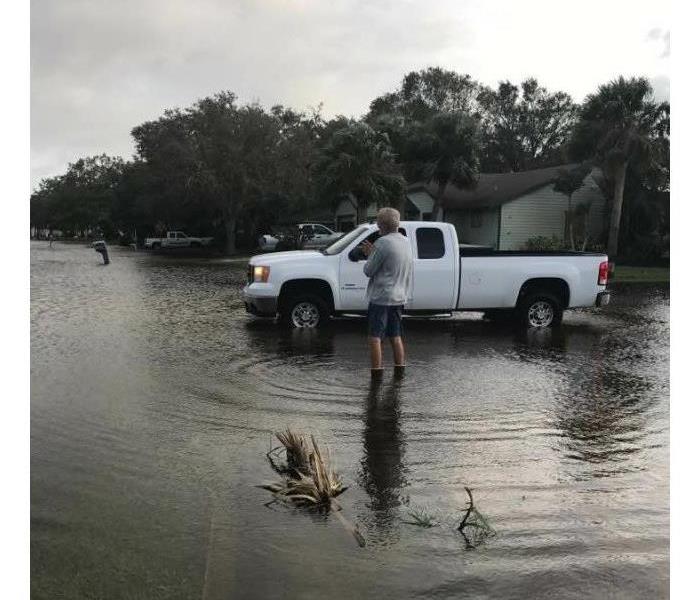 man and white truck in flooding water
