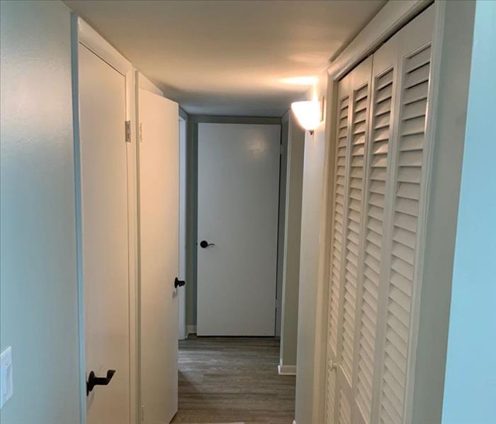Hallway of condo with molding and base boards replaced on all doors on the left side. 