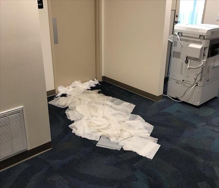 Blue carpet in clinic with paper towels spread out to soak up water.  