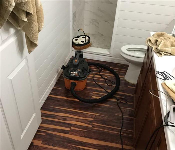 Master bathroom with water damaged laminate flooring.