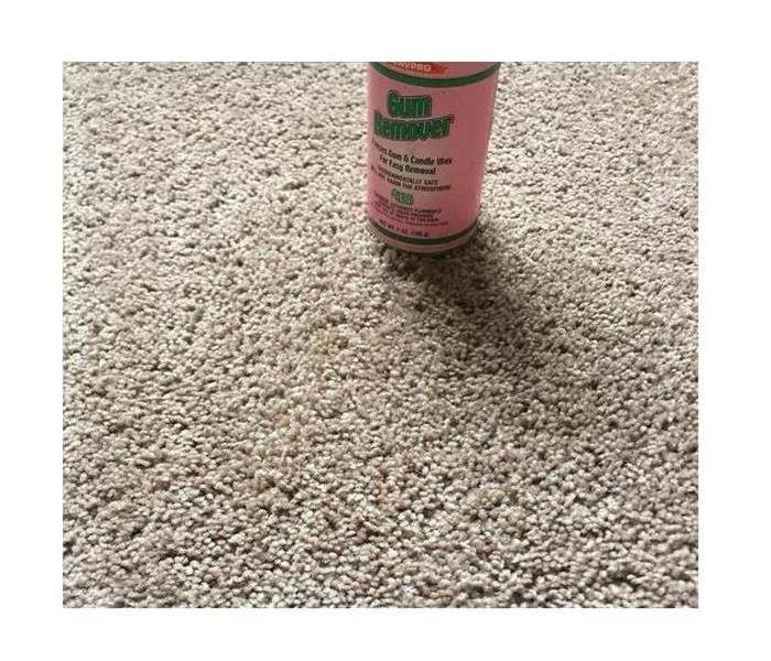 Clean beige carpet fibers with a bottle of SERVPRO Gum Remover toward the top of the image