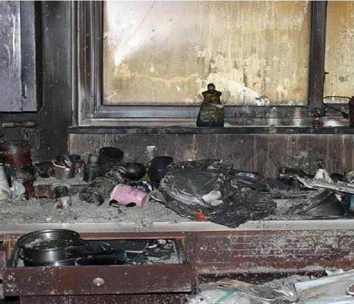 Kitchen burned and covered in soot from a fire.