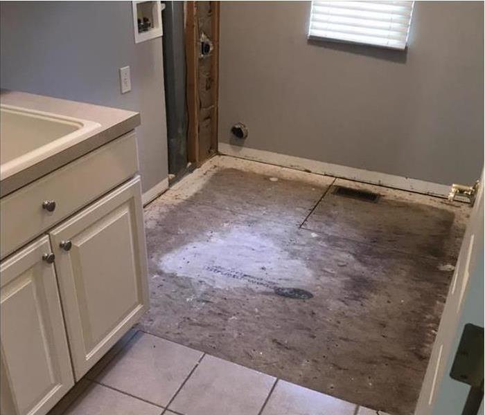 Laundry room with section of floor removed after being damaged from a leaking washing machine.