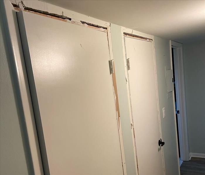 Hallway of condo with molding and base boards removed from all doors on the left side. 