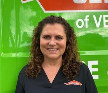White female with brown hair wearing a black SERVPRO® shirt and smiling