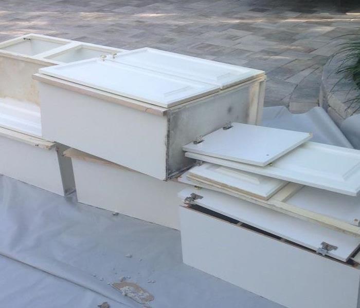 white moldy cabinets stacked neatly on plastic