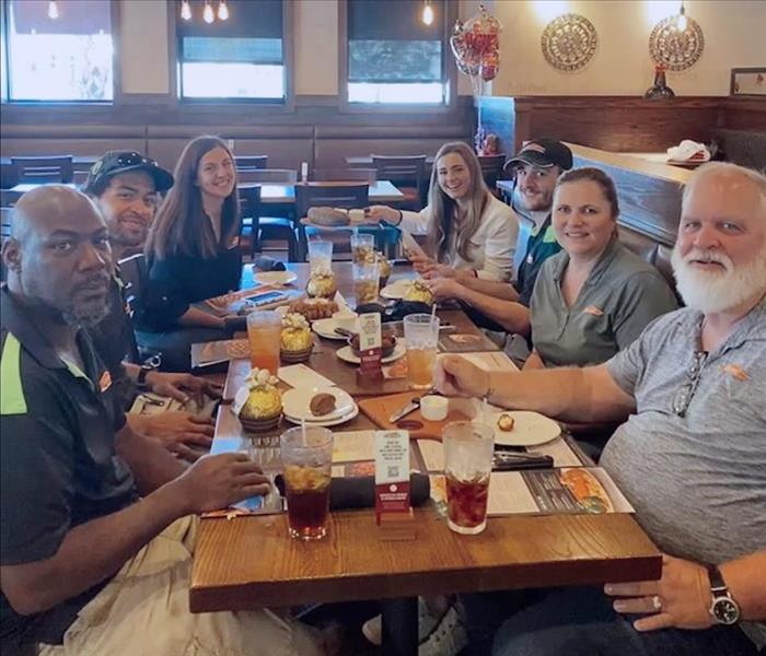 Seven people gathered around a table at Outback Steakhouse in Vero Beach