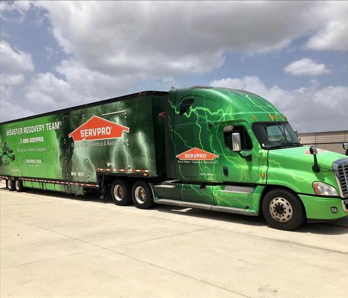 A SERVPRO Disaster Recovery semi truck parked in an open lot. 
