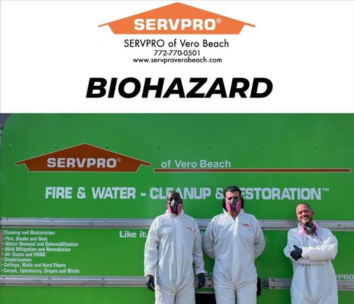 three men standing in front of servpro box truck in ppe