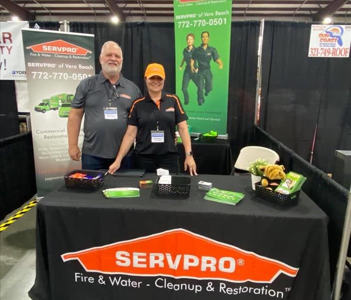 Man and woman standing at a SERVPRO booth