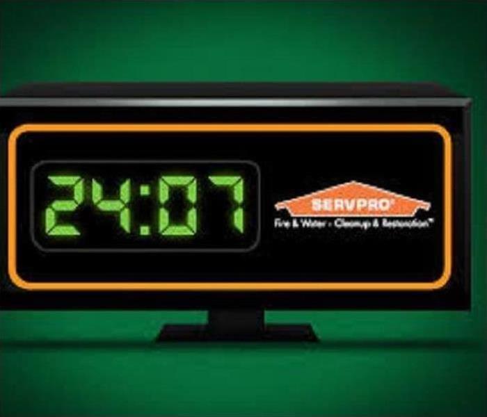 Alarm clock with “24:07” on the left and the SERVPRO logo on the right. 