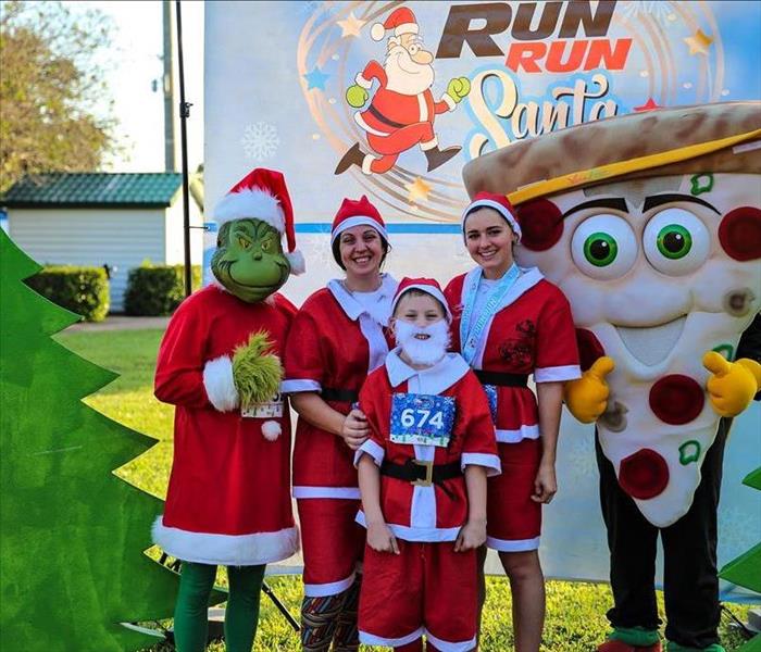 3 runners dressed up as Santa posing for a picture
